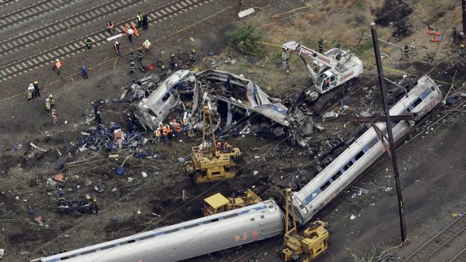 Emergency personnel work at the scene of a deadly train derailment, Wednesday, May 13, 2015, in Philadelphia. The Amtrak train, headed to New York City, derailed and crashed in Philadelphia on Tuesday night, killing at least six people and injuring dozens of others. (AP Photo/Patrick Semansky)