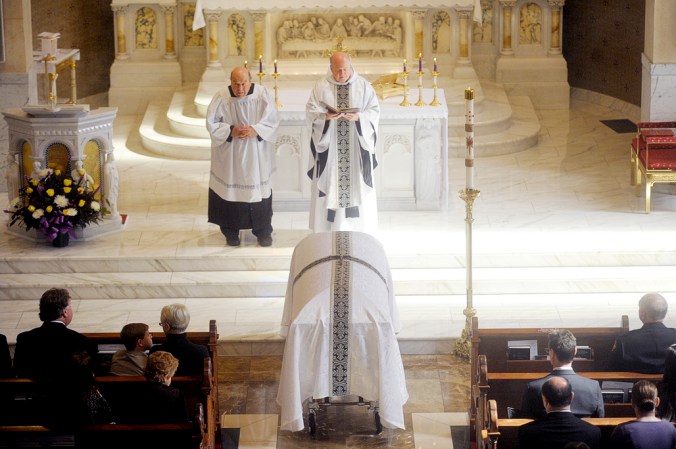 NICK SCHNELLE/JOURNAL STAR Pastor Larry Zurek leads a funeral mass for former Peoria Fire Cheief Ernie Russell on Friday morning at Sacred Heart Catholic Church. Russell was 74.