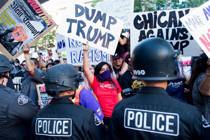 Police form a line to contain protesters outside a campaign rally for Republican presidential candidate Donald Trump on Thursday, June 2, 2016, in San Jose, Calif.  A group of protesters attacked  Trump supporters who were leaving the presidential candidate's rally in San Jose on Thursday night. A dozen or more people were punched, at least one person was pelted with an egg and Trump hats grabbed from supporters were set on fire on the ground. (AP Photo/Noah Berger)
